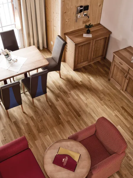 Appartements
in Obertauern. Gemütliches Hotelzimmer mit Holzmöbeln, Esstisch, Sesseln und wandmontiertem Fernseher